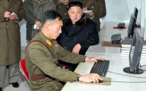 észak-Koreai hacker, a háttérben Kim Dzsongun